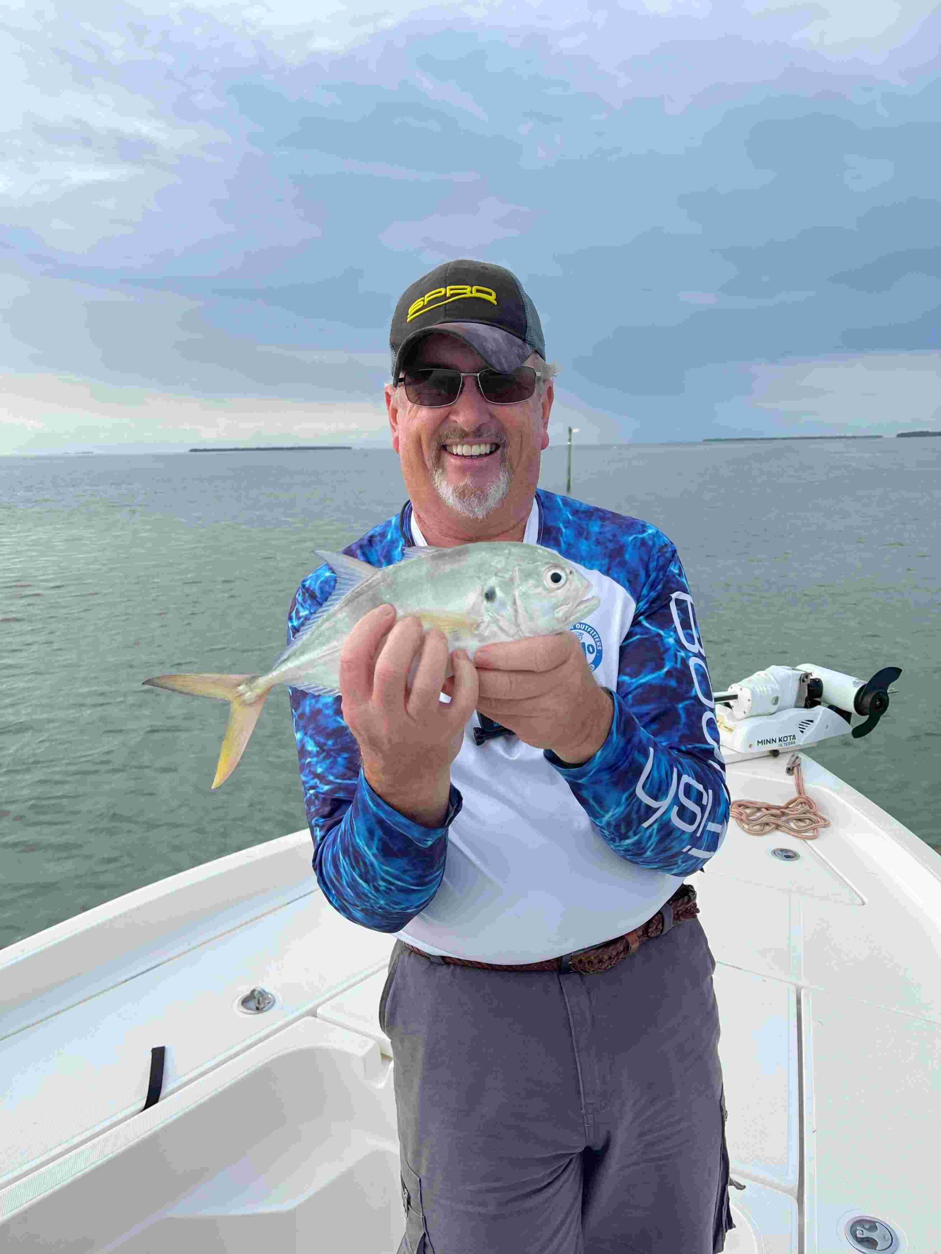 Guy Wann holding a small Crevalle jack in the midst of a powerful sprint through the open sea. The Crevalle jack